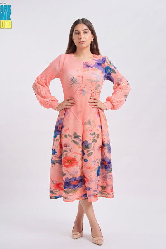 A woman modeling a peach pink long-sleeve kurta with a colorful floral print, standing against a light gray studio background.