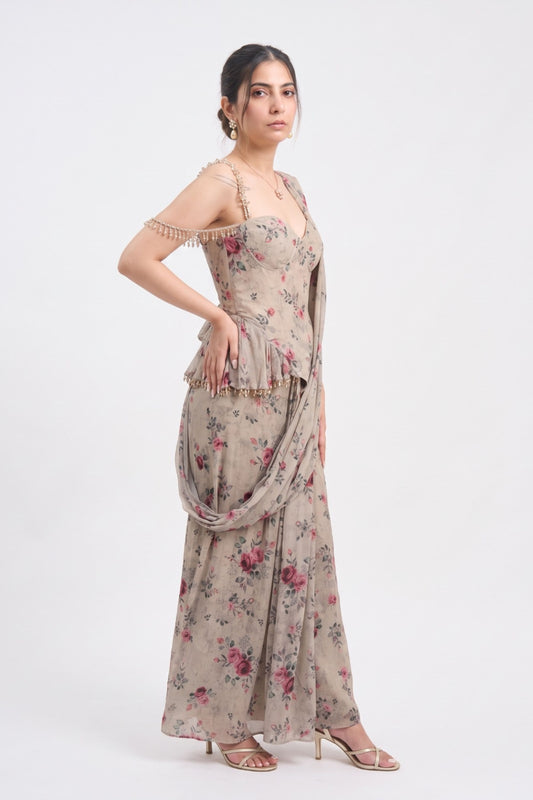 A woman modeling a beige floral off-the-shoulder maxi dress with a draped dupatta, standing against a plain white studio background.