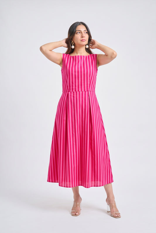 A woman modeling a sleeveless midi dress with vertical pink and white stripes, standing against a light gray studio background.