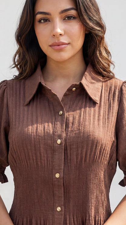 Woman wearing a brown dress with a plain background