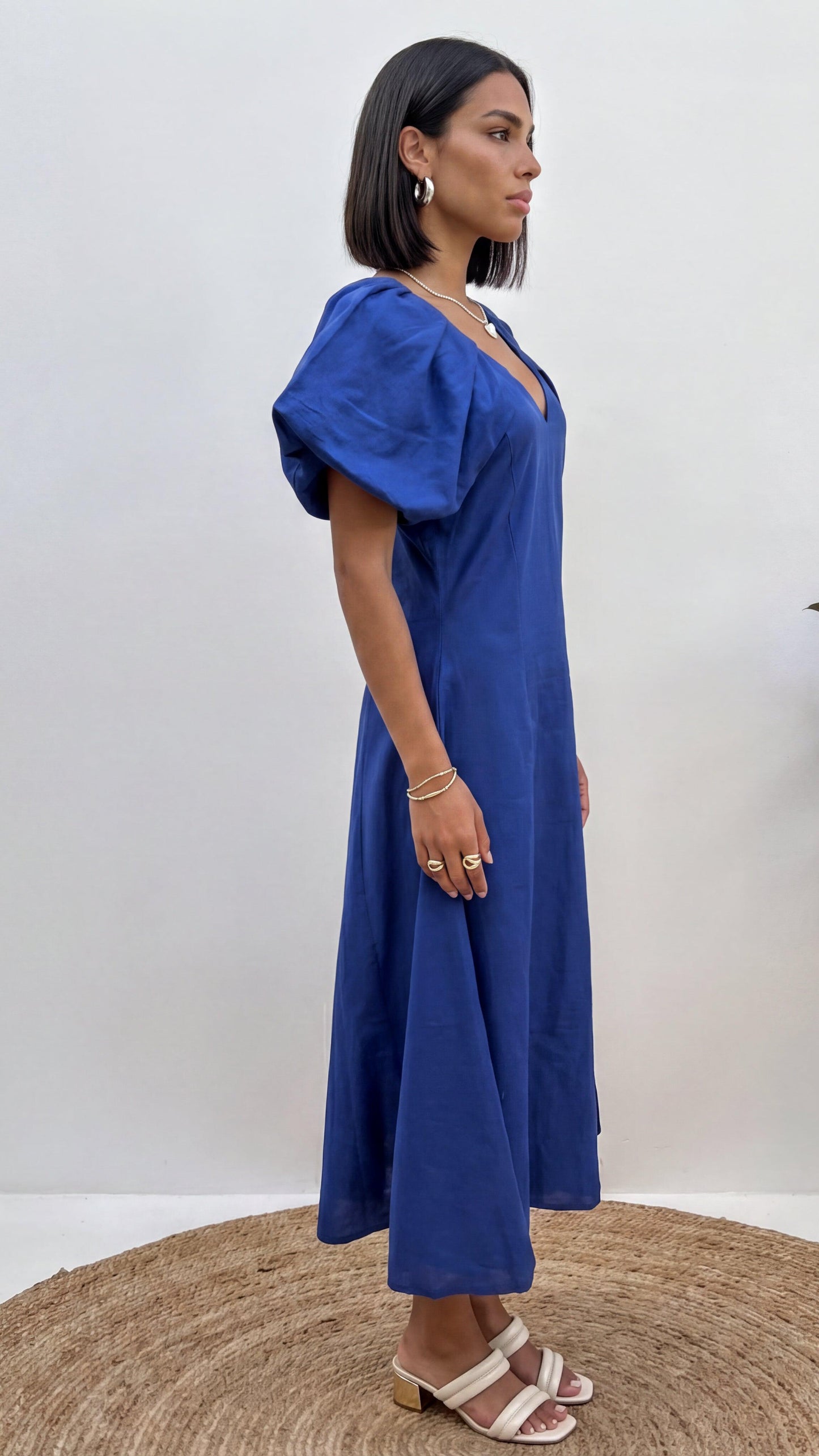 Woman wearing a blue dress standing on a white background