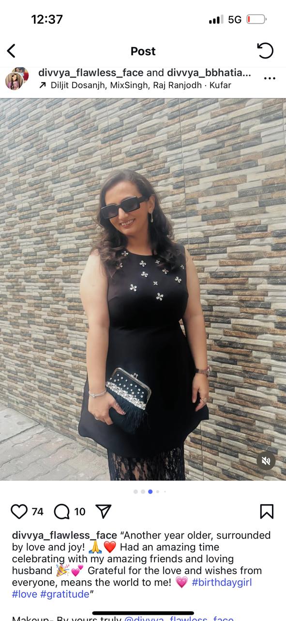 Woman in a black dress standing against a stone wall