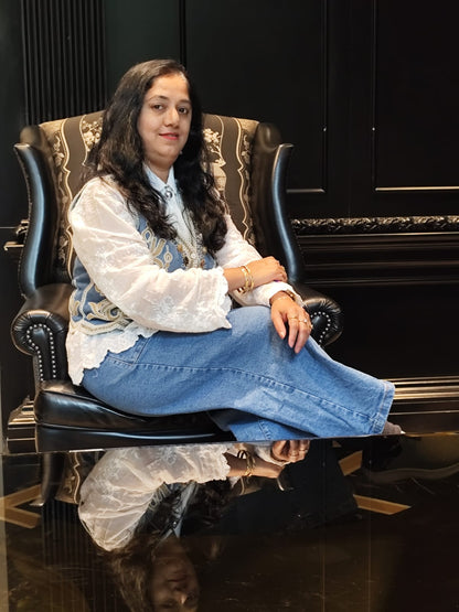 Woman sitting on a decorative chair with a reflective surface below