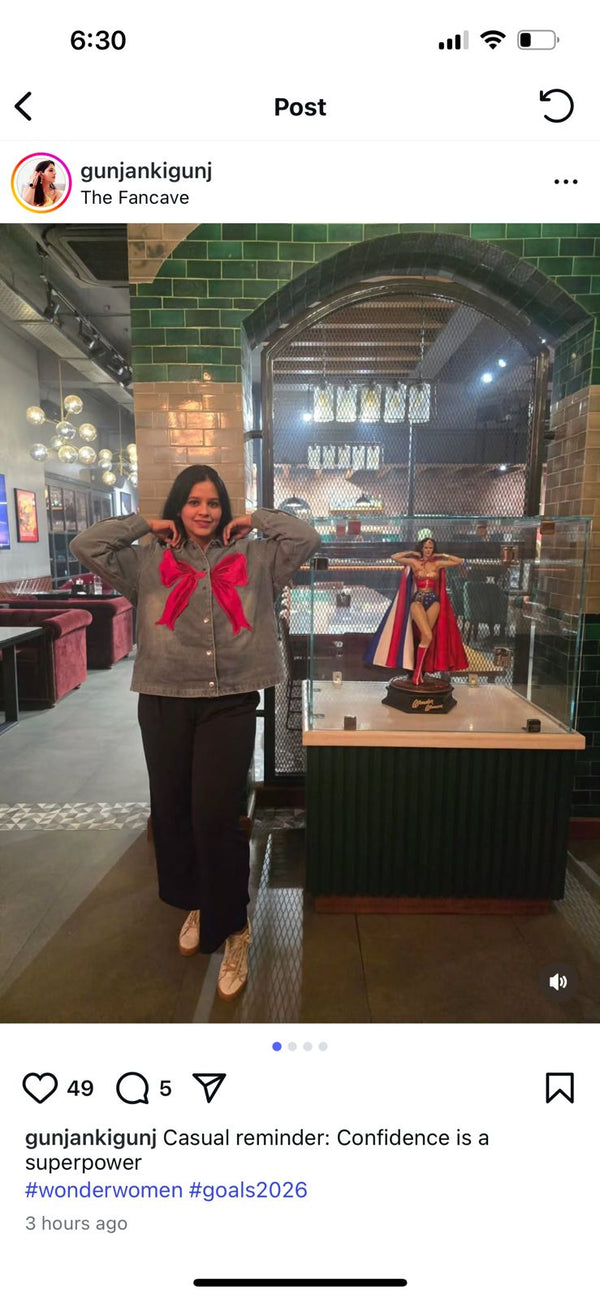 Person standing in a museum-like setting with a display case and statue.