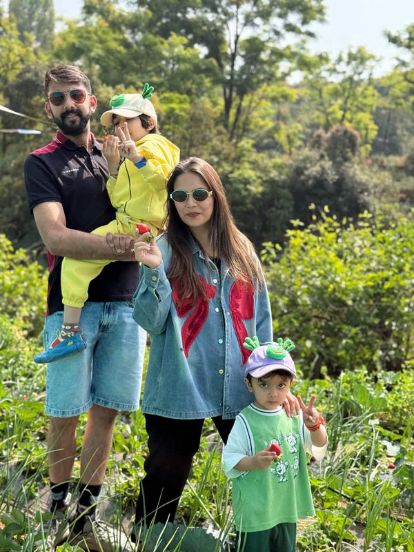 Family of four outdoors in a natural setting with greenery
