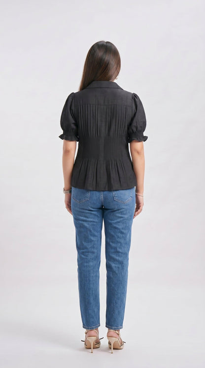 Woman wearing a black blouse and blue jeans on a white background