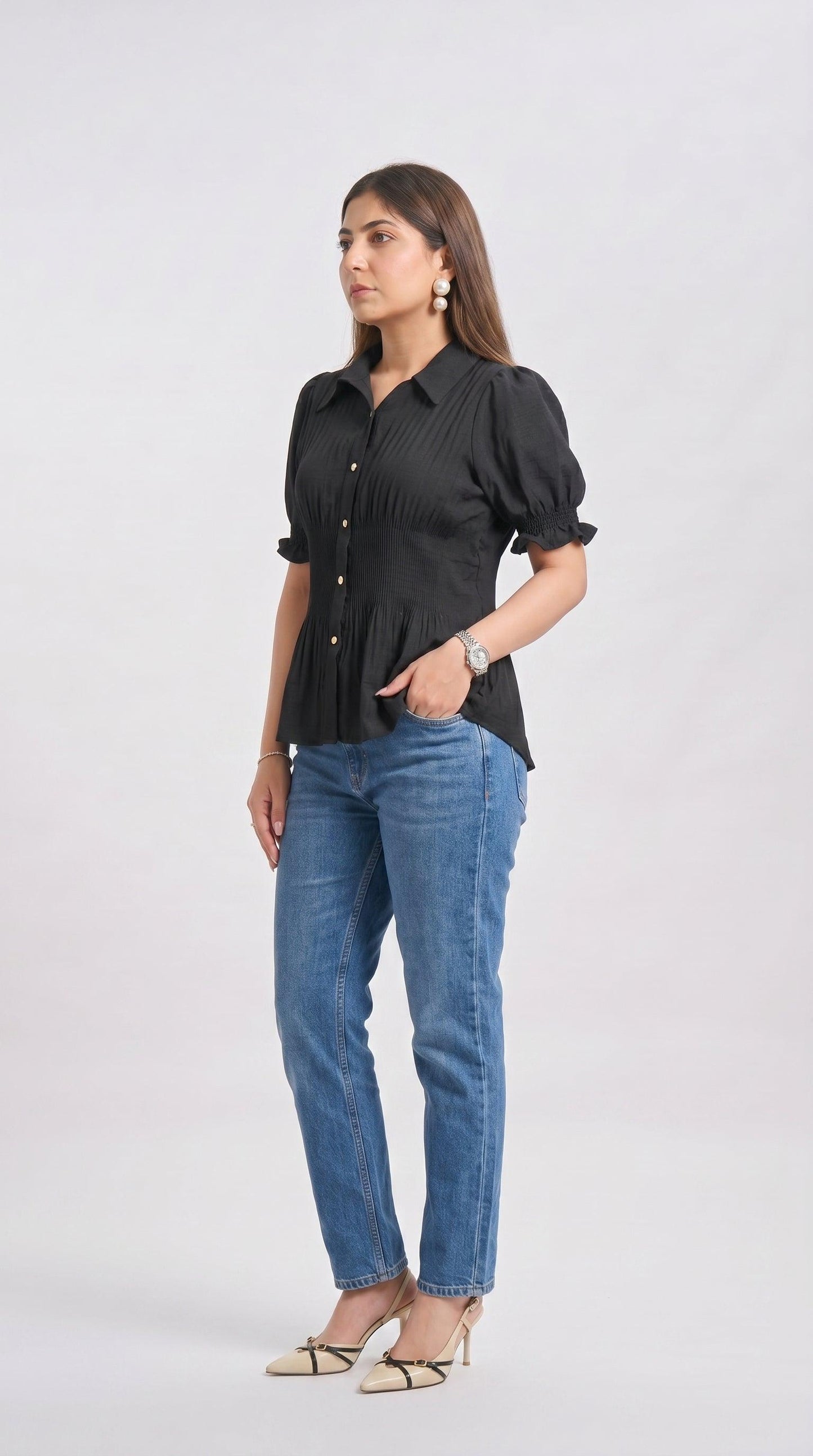 Woman wearing a black blouse and blue jeans on a white background