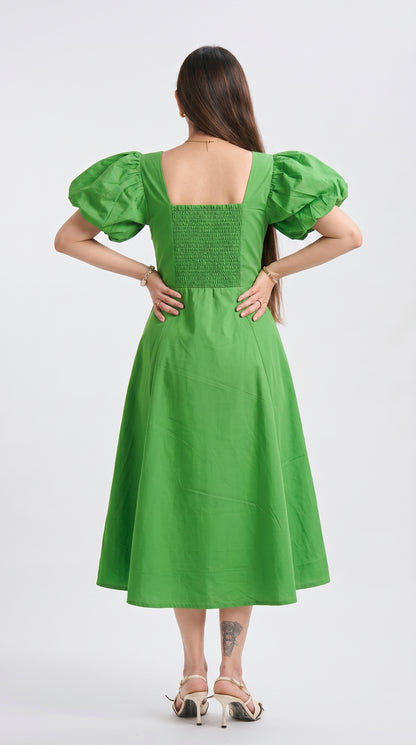 Green dress with puff sleeves worn by a person on a white background