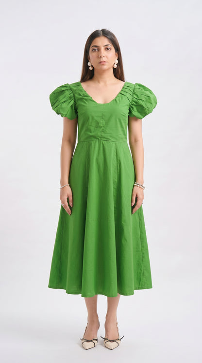 Woman wearing a green dress with puffed sleeves on a white background