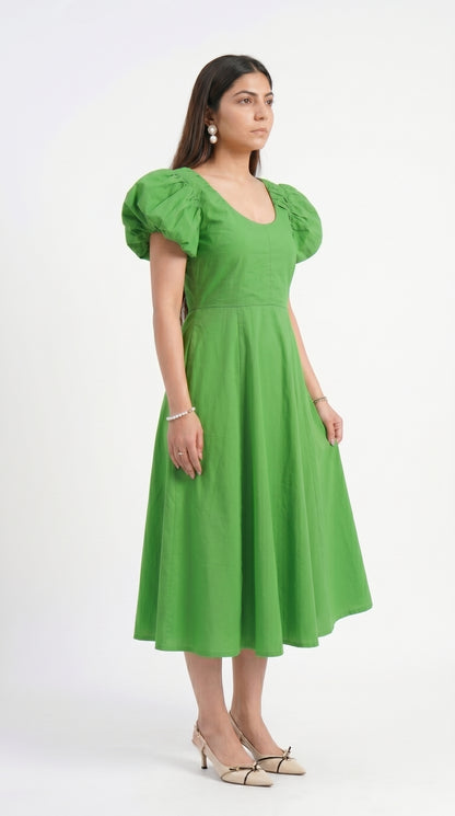 Woman wearing a green dress with puff sleeves on a white background