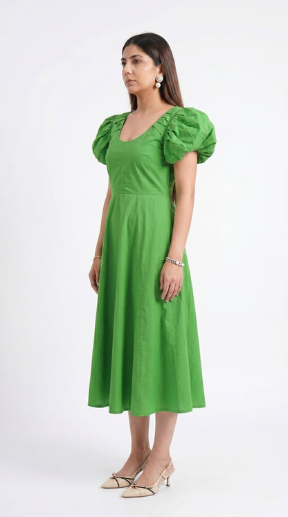 Woman wearing a green dress with puff sleeves on a white background