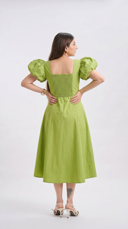 Woman wearing a green dress with puffed sleeves on a white background