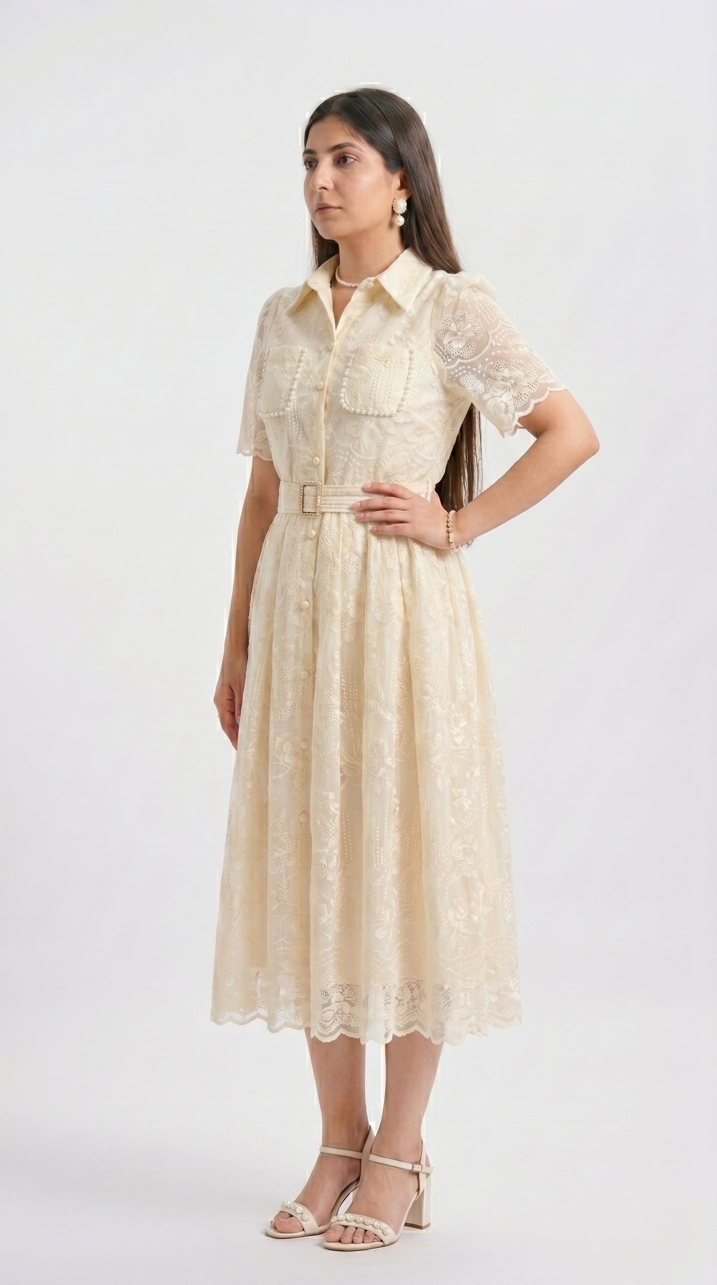 Woman wearing a beige dress with a belt on a white background