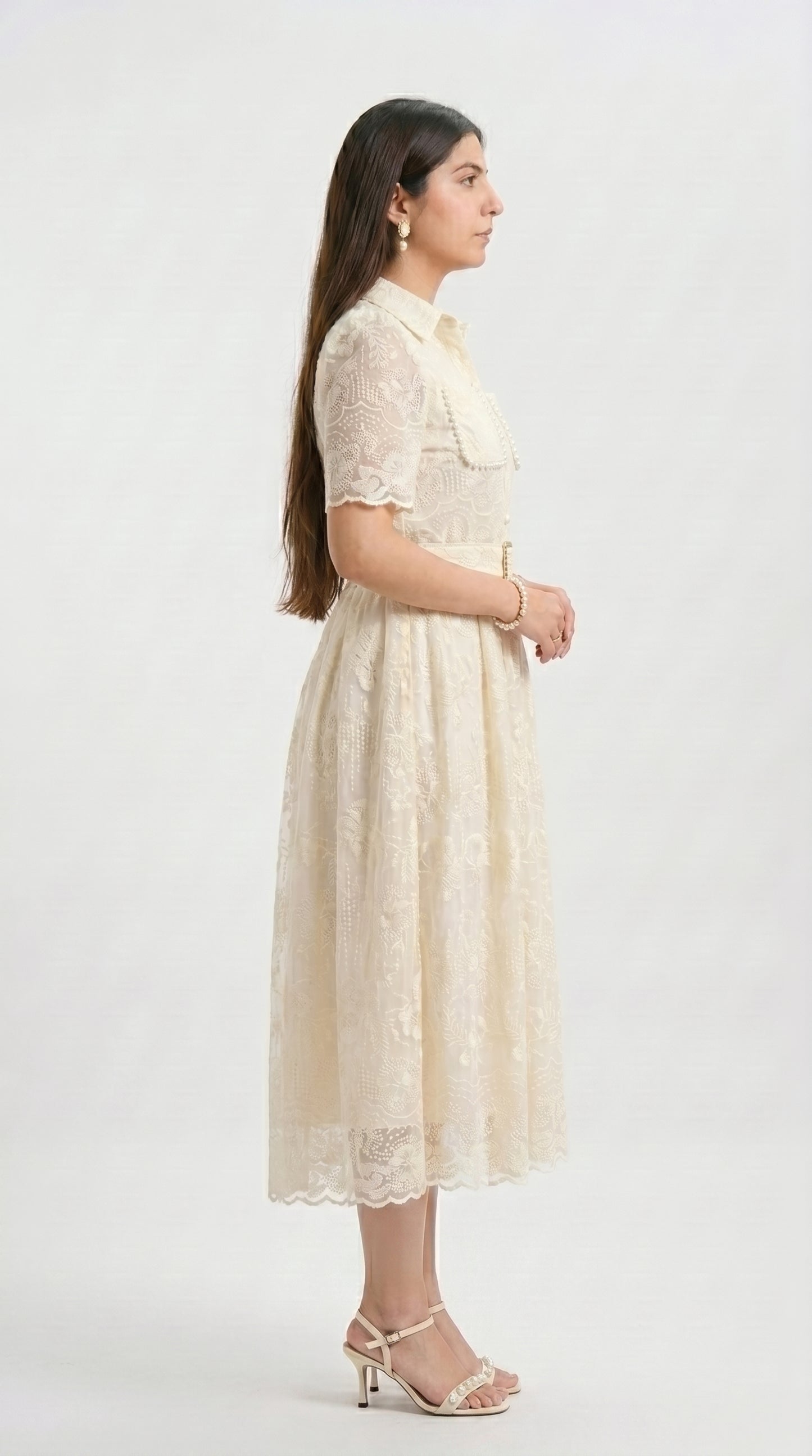 Woman wearing a beige lace dress on a white background