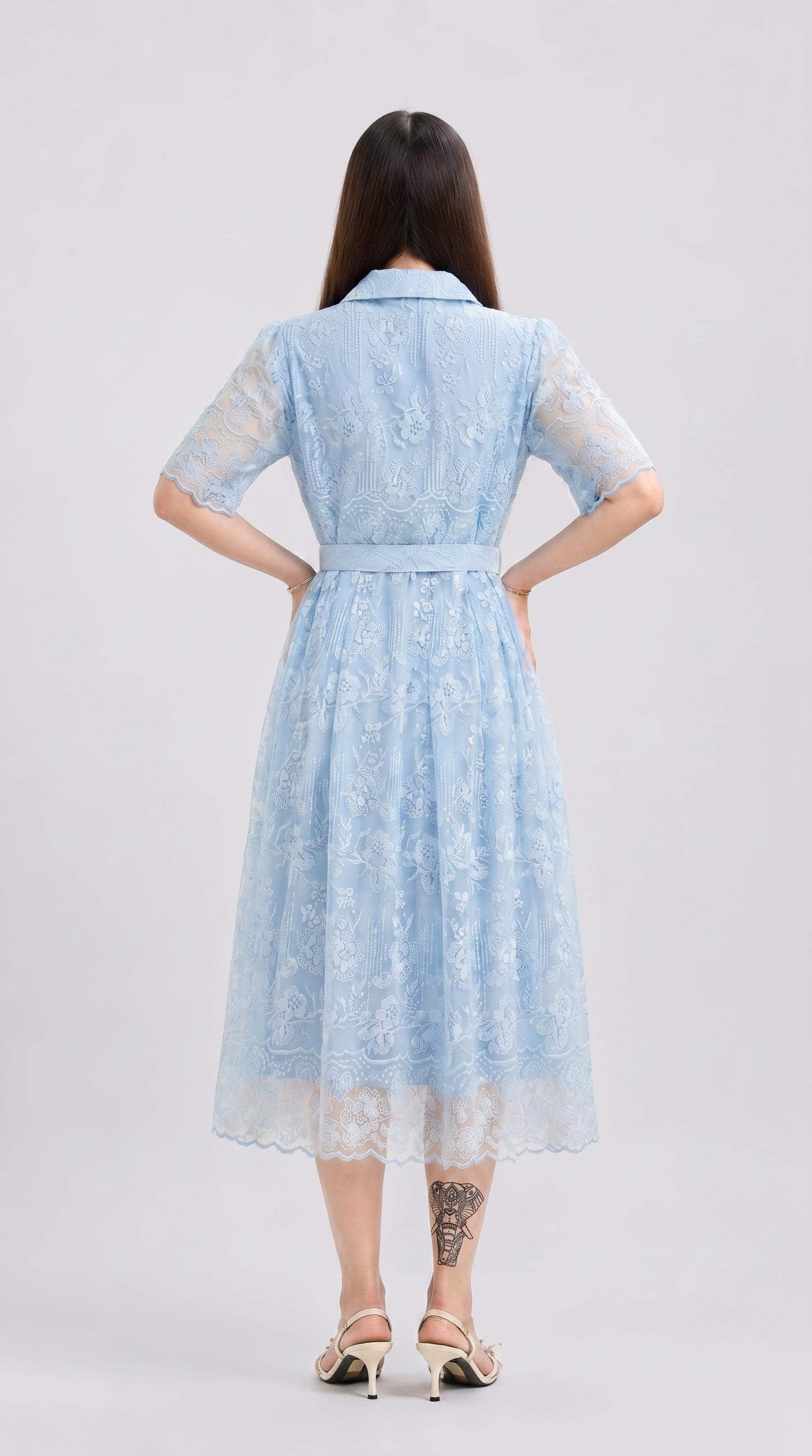 Woman wearing a light blue lace dress on a white background