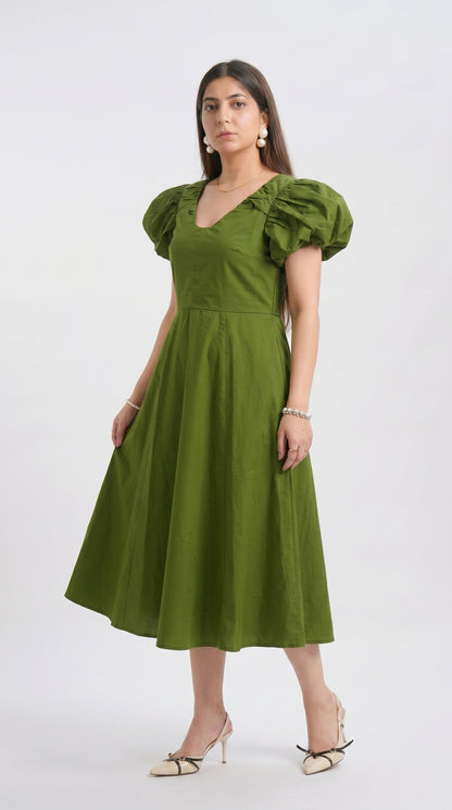 Woman wearing a green dress with puff sleeves on a white background