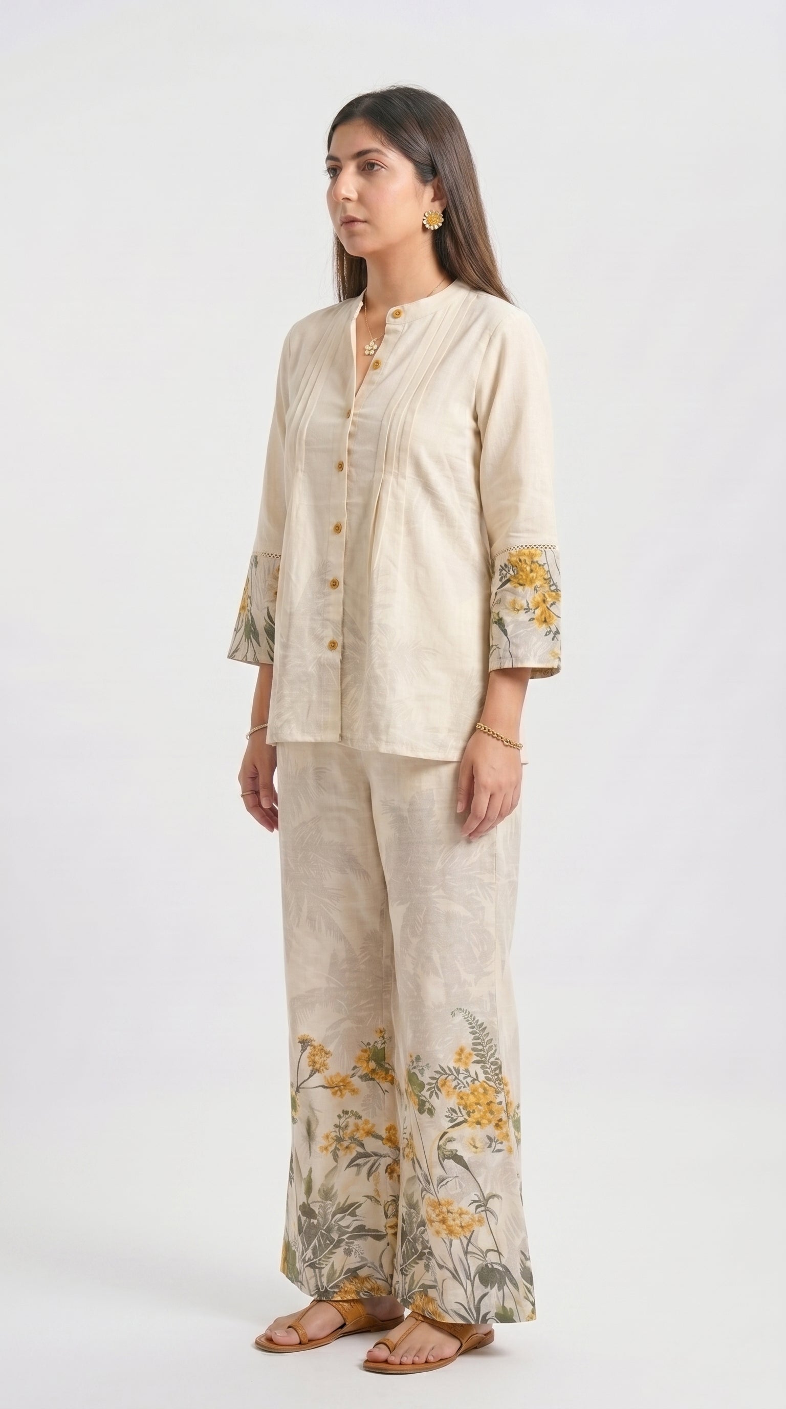 Woman wearing a beige outfit with floral patterns on a white background