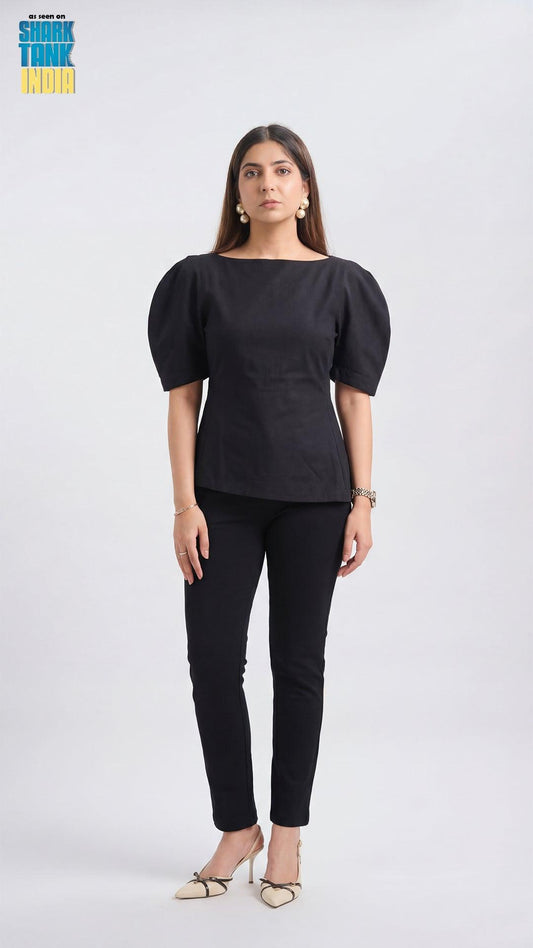 Woman wearing a black outfit with puffed sleeves on a white background