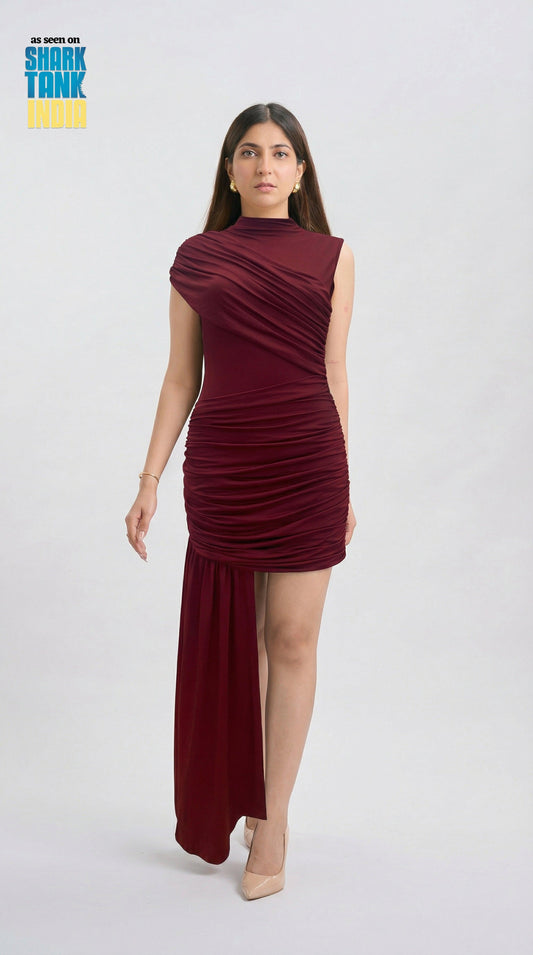 Woman wearing a burgundy dress on a white background with 'Shark Tank' branding.