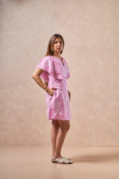 Woman wearing a pink dress against a beige background