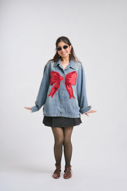 Woman wearing a denim shirt with red bows on a white background