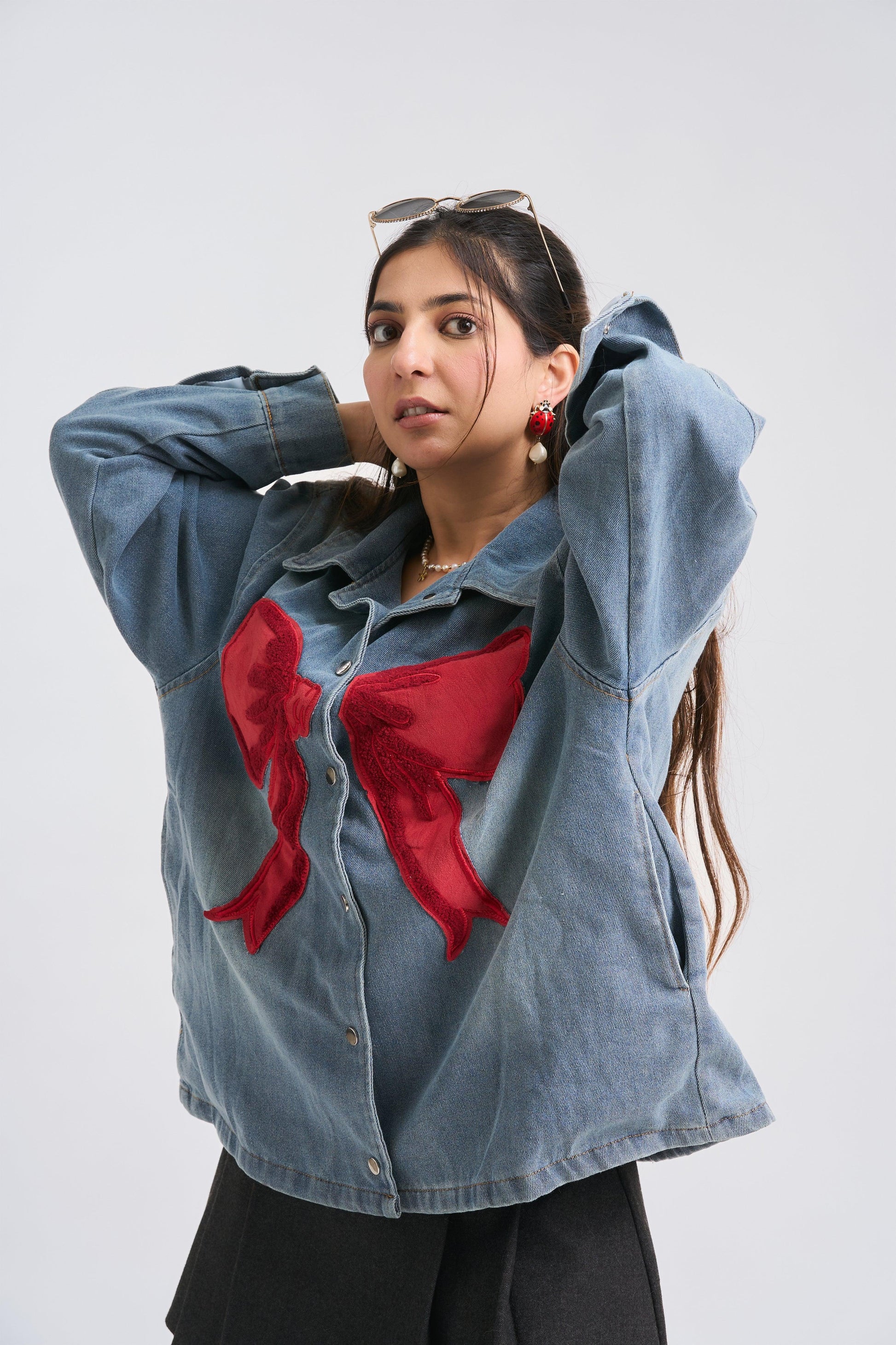 Woman wearing a denim jacket with a red design on a white background