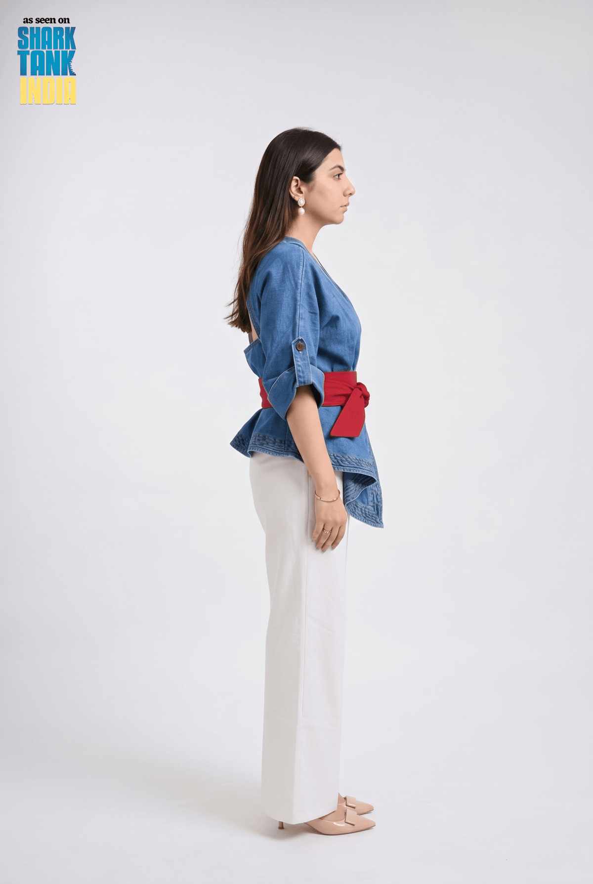 Woman wearing a blue denim jacket with red accents on a white background, featuring Shark Tank branding.