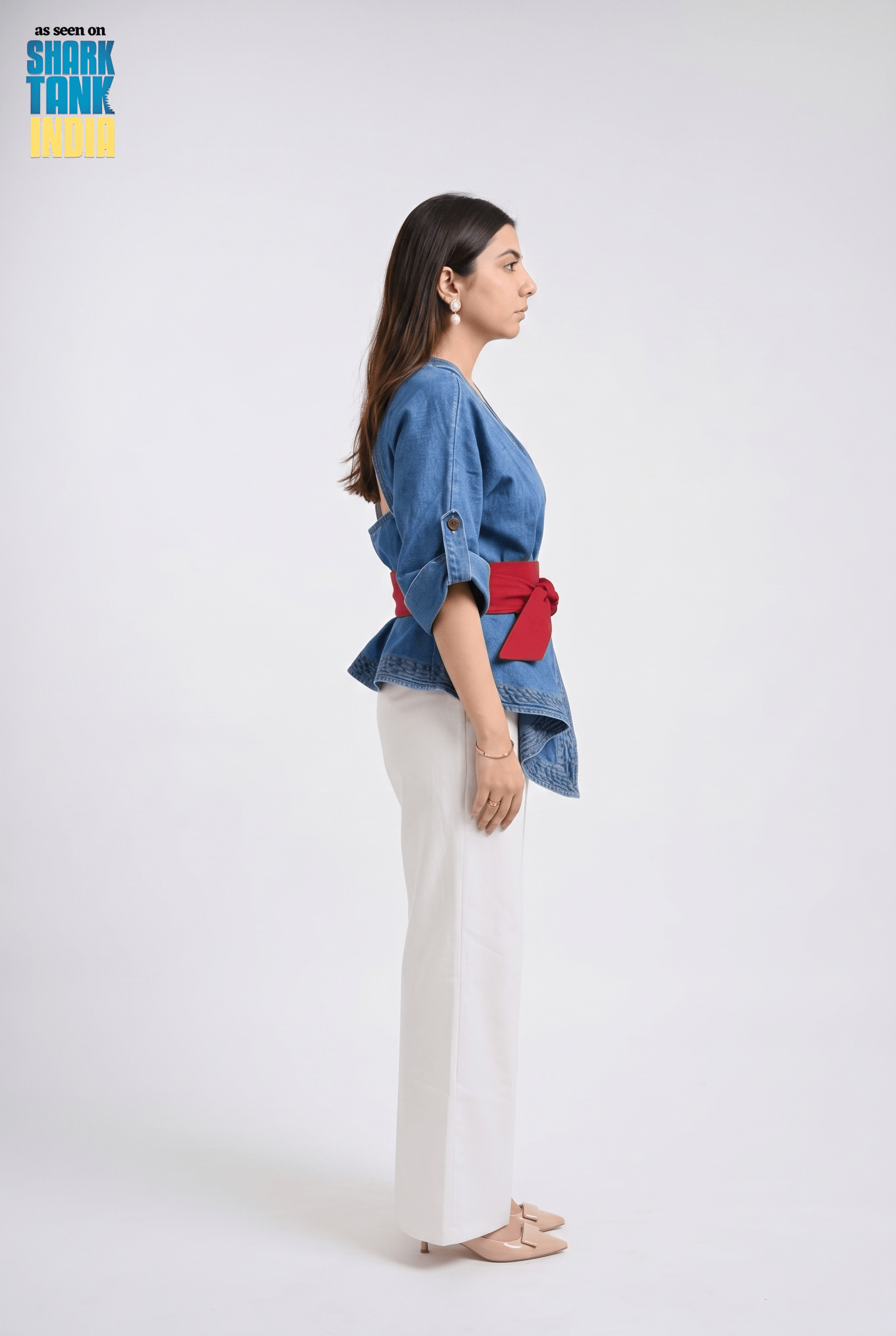 Woman wearing a blue denim jacket with red accents on a white background, featuring Shark Tank branding.