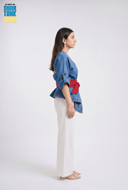 Woman wearing a blue denim jacket with red accents on a white background, featuring Shark Tank branding.