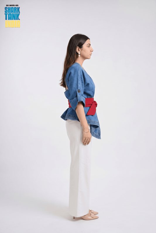 Woman wearing a blue denim jacket with red accents on a white background, featuring Shark Tank branding.