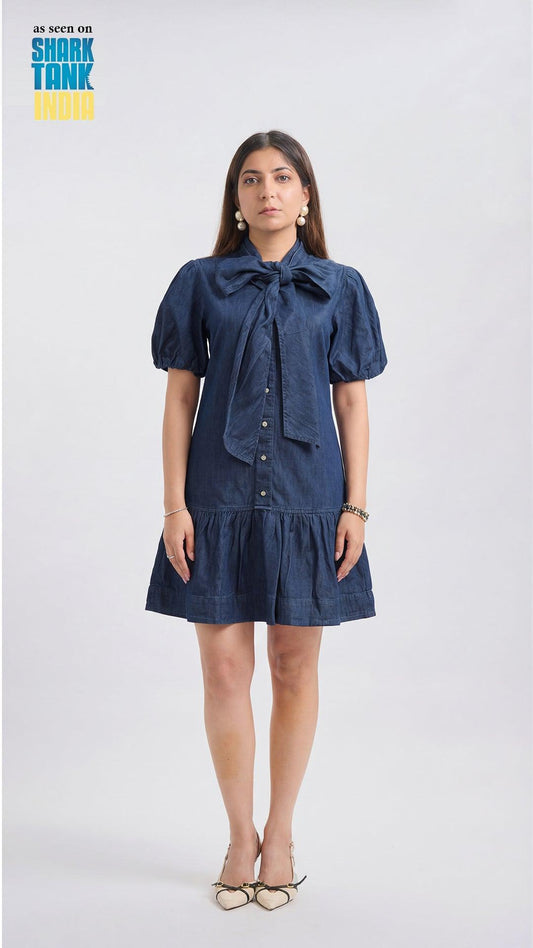Woman wearing a blue dress with a bow tie on a white background