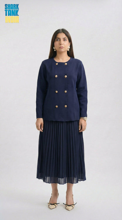 Woman wearing a navy blue outfit with a jacket and pleated skirt on a white background