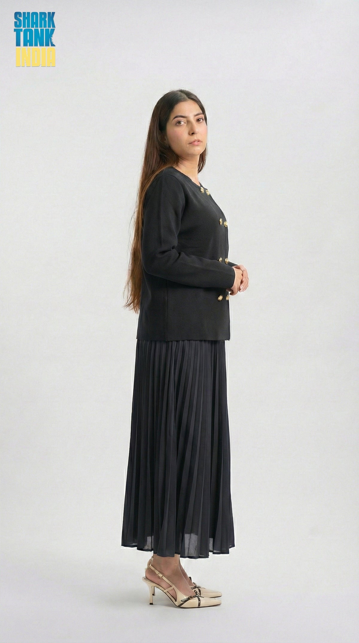 Woman wearing a black outfit with a long skirt on a white background
