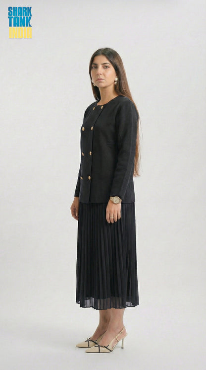 Woman wearing a black outfit with gold buttons on a white background