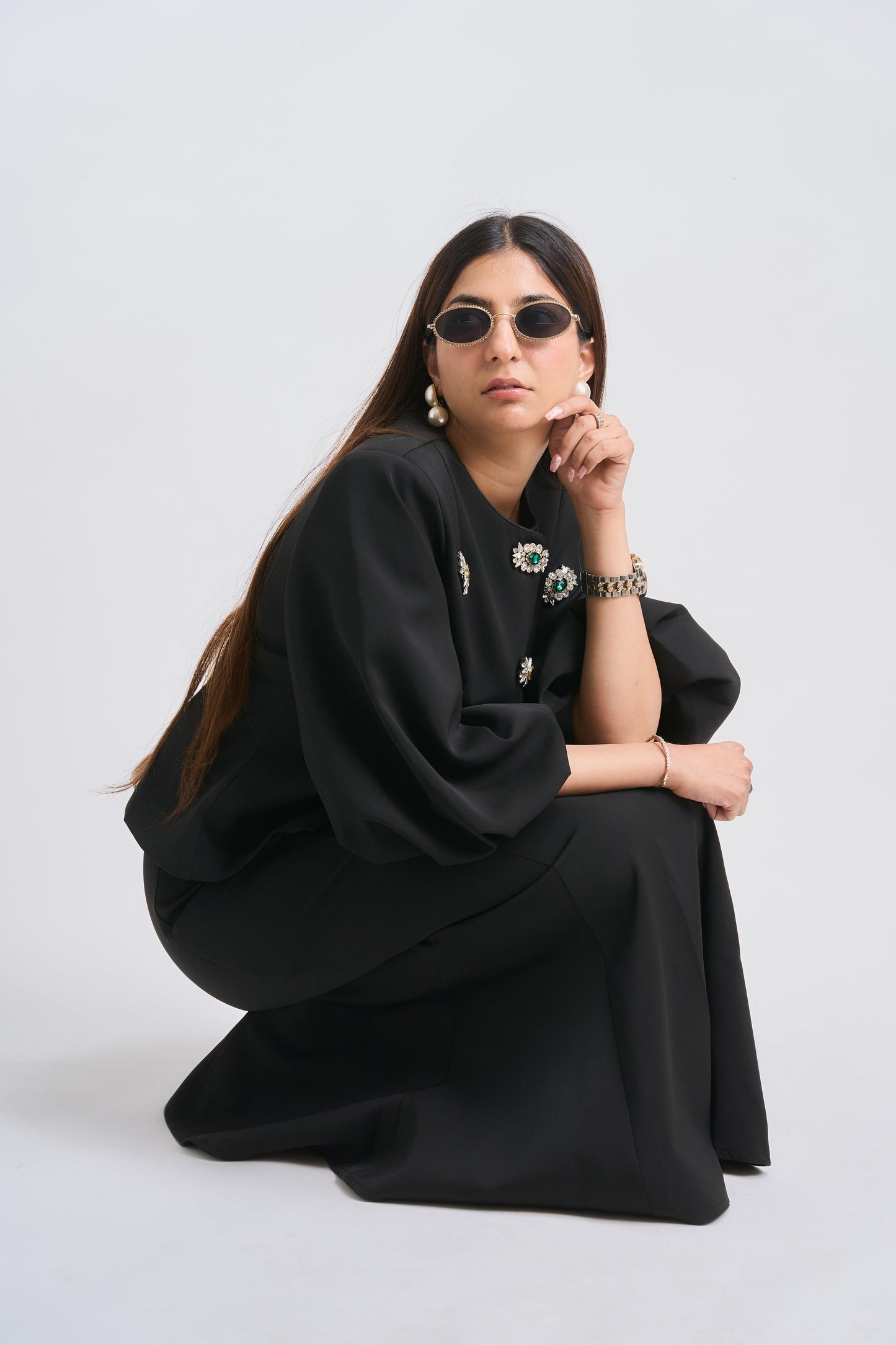 Woman wearing a black outfit with floral details on a white background