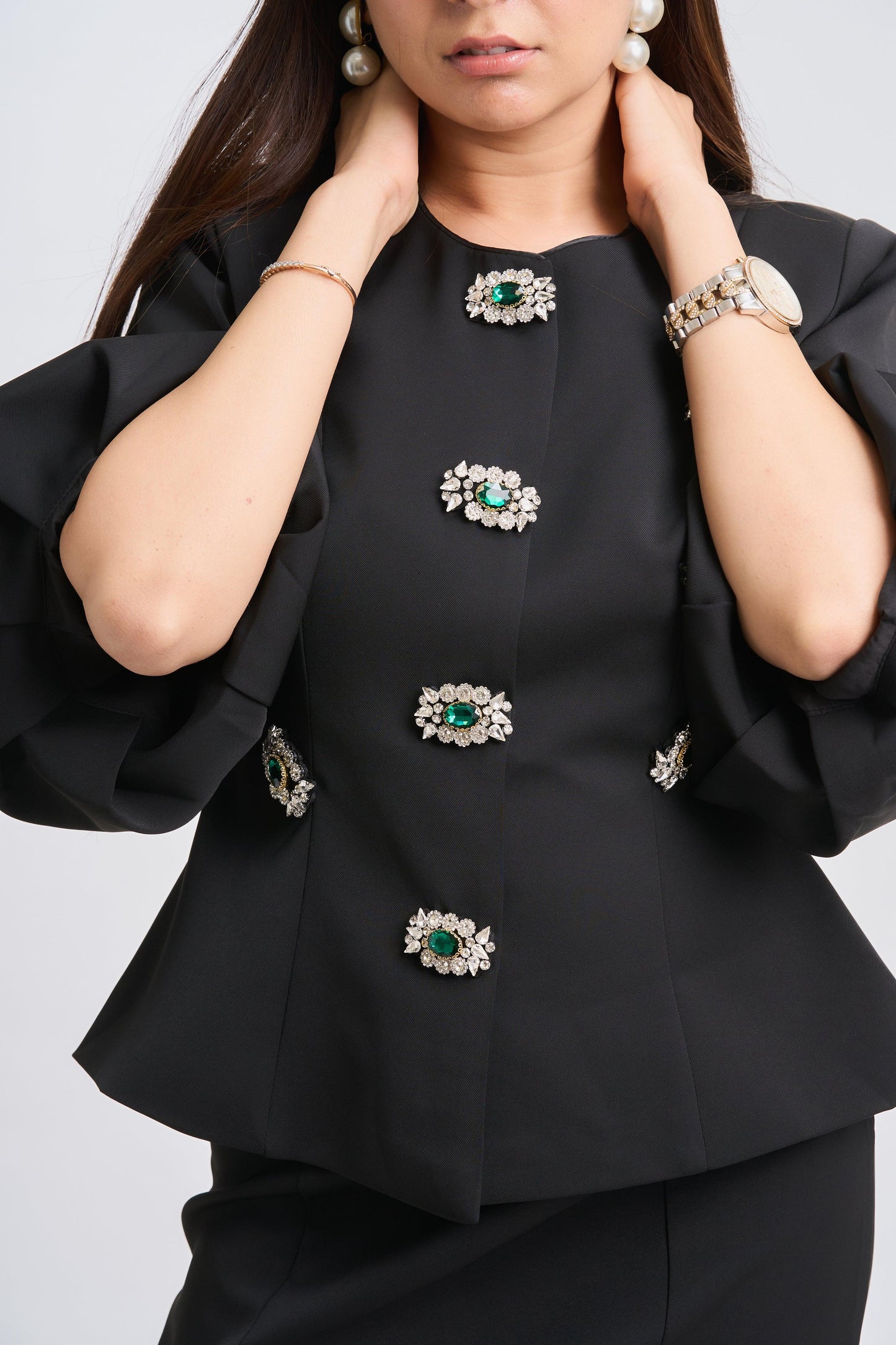 Black outfit with decorative buttons on a plain background