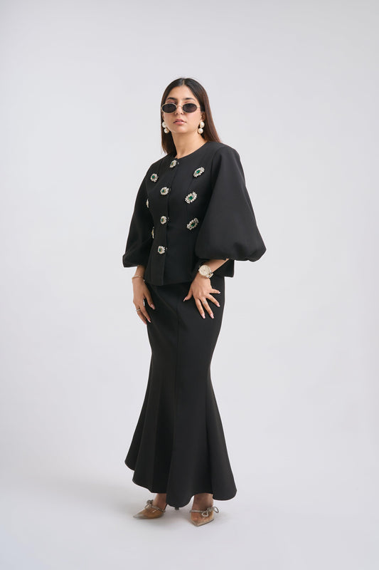 Woman wearing a black outfit with a jacket and skirt on a white background