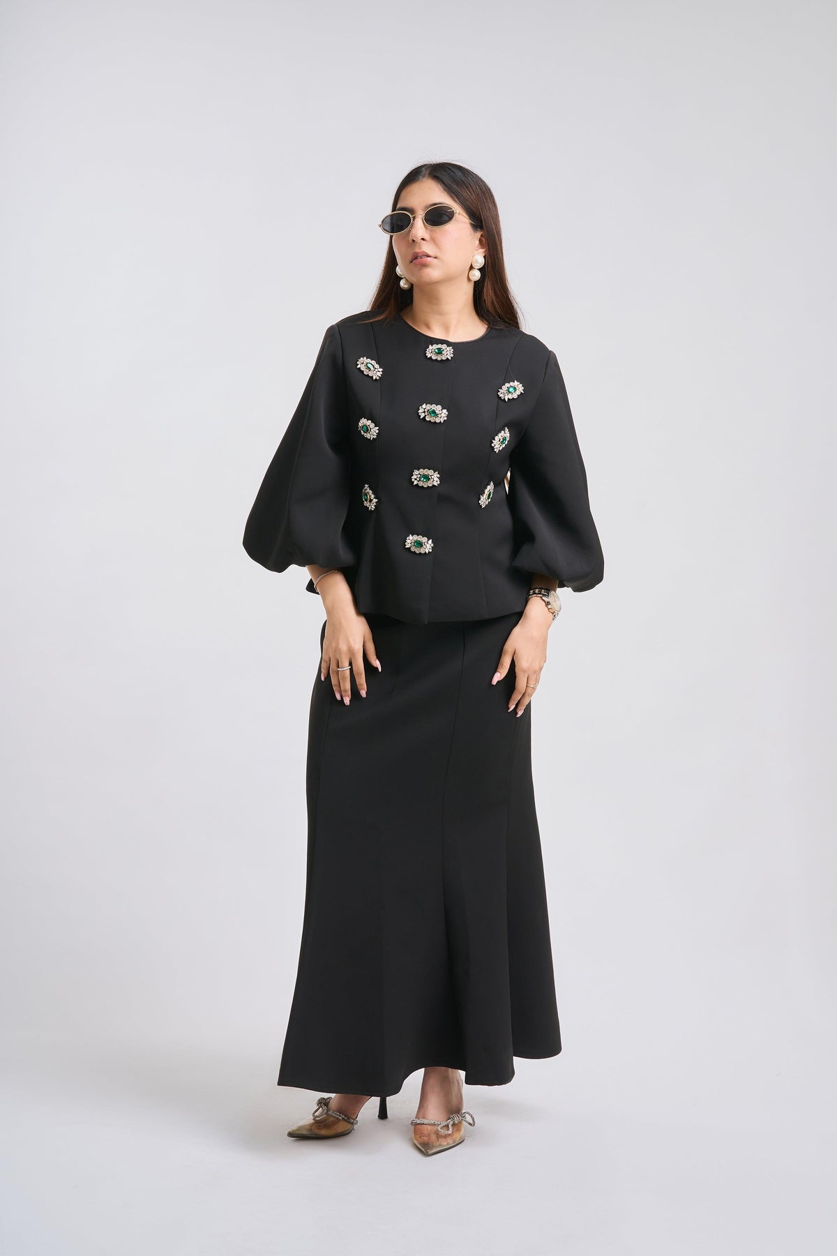 Woman wearing a black outfit with decorative elements on a white background