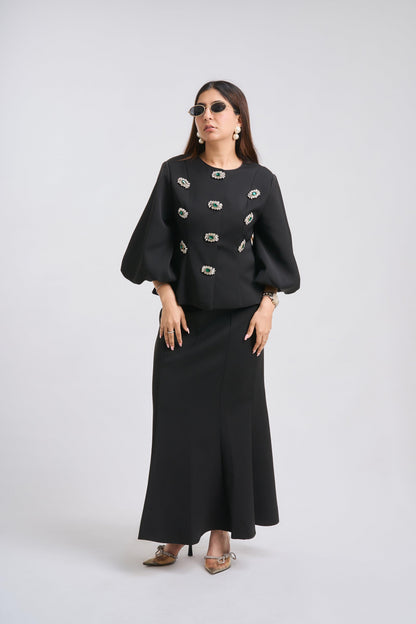 Woman wearing a black outfit with decorative elements on a white background