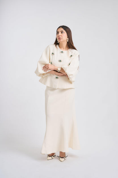 Woman wearing a white outfit with green buttons on a white background