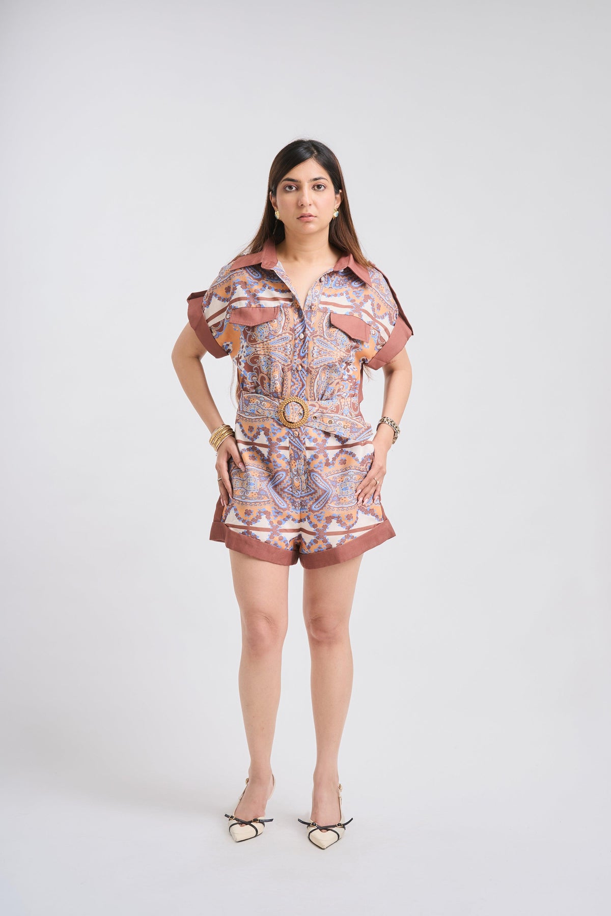 Woman wearing a patterned romper on a white background