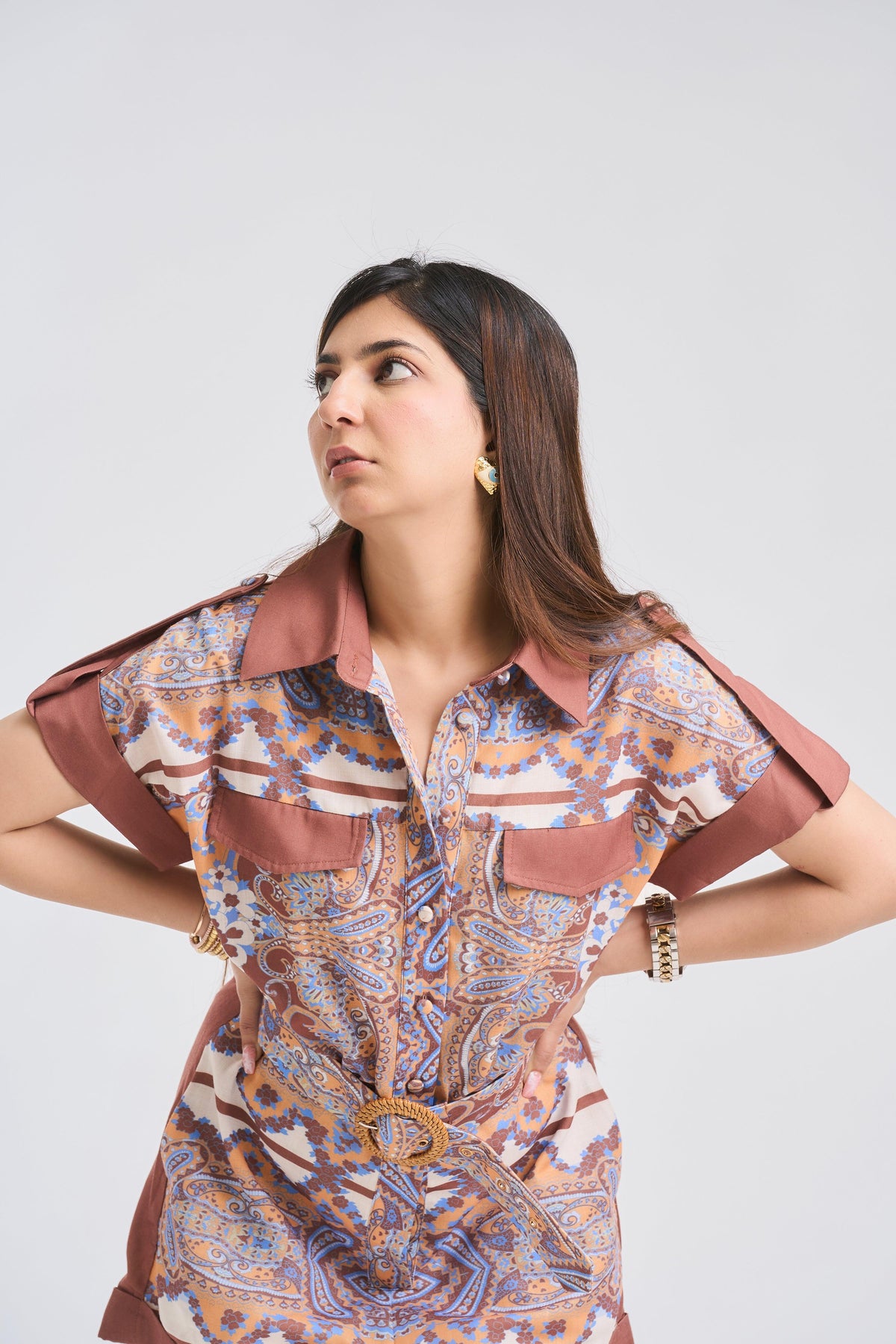 Woman wearing a patterned dress with a belt on a white background