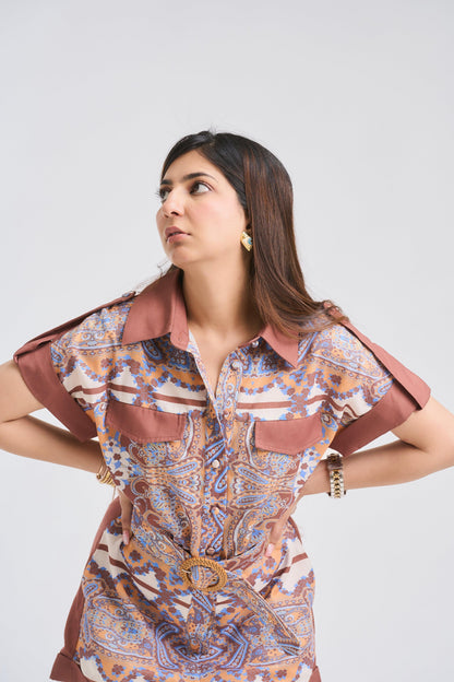 Woman wearing a patterned dress with a belt on a white background