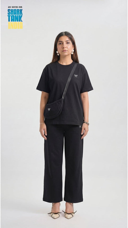Woman wearing a black outfit with a crossbody bag on a white background