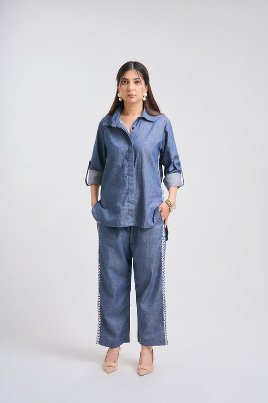Woman wearing a blue outfit with a plain background