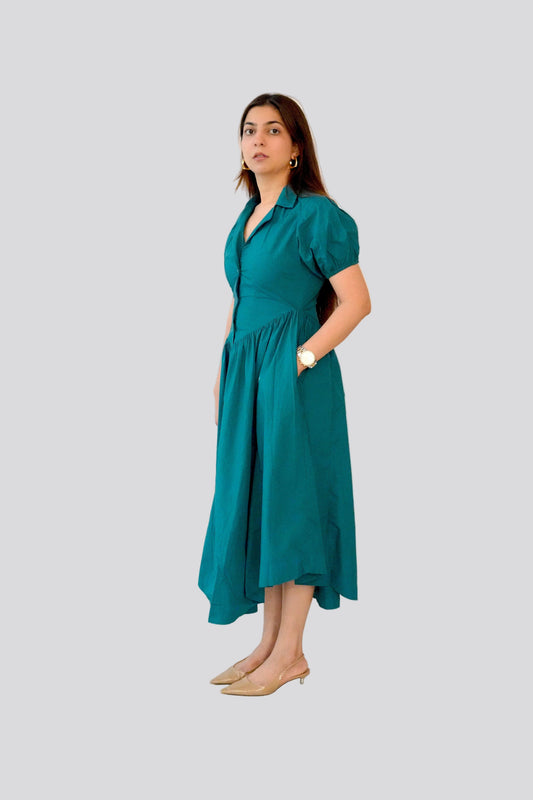 Woman wearing a teal dress on a light gray background