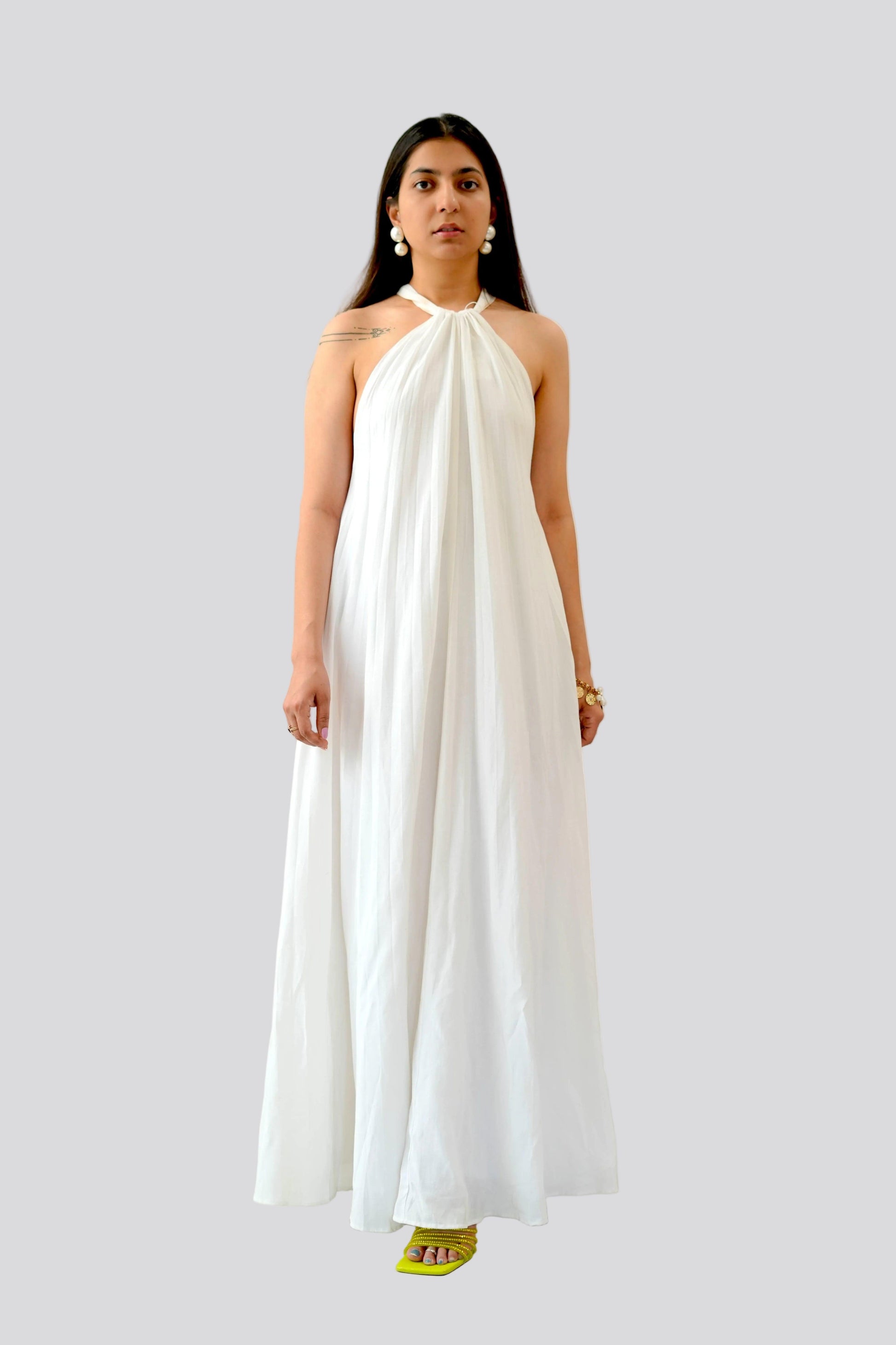 Woman wearing a white halter neck dress on a light gray background