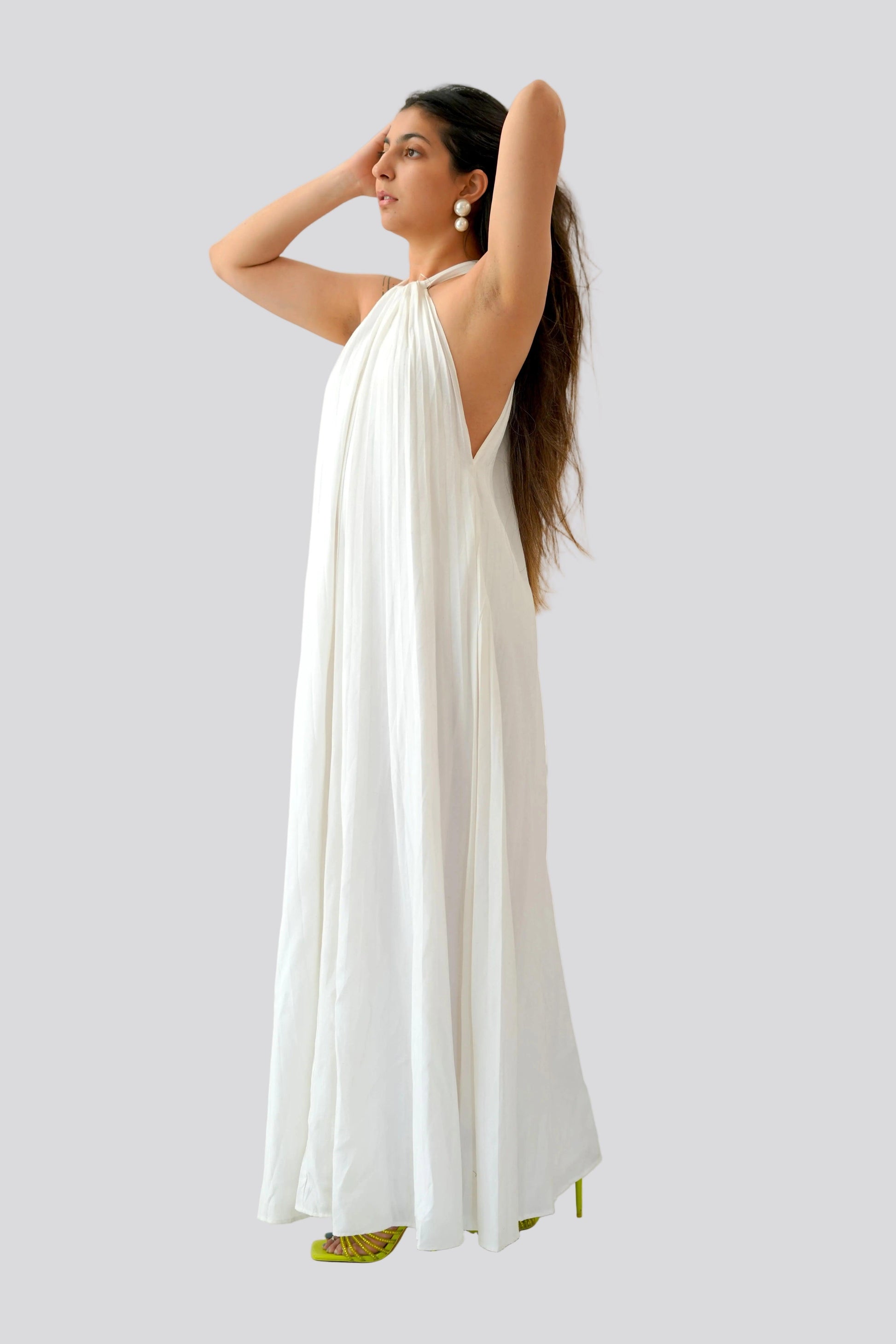 Woman wearing a white dress with green accents on a light gray background
