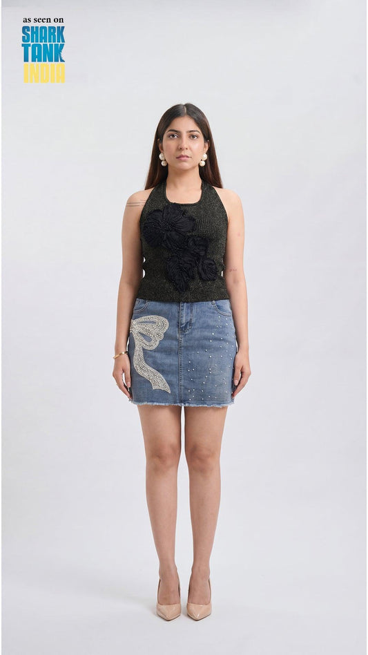 Woman wearing a black top and denim skirt with a white background