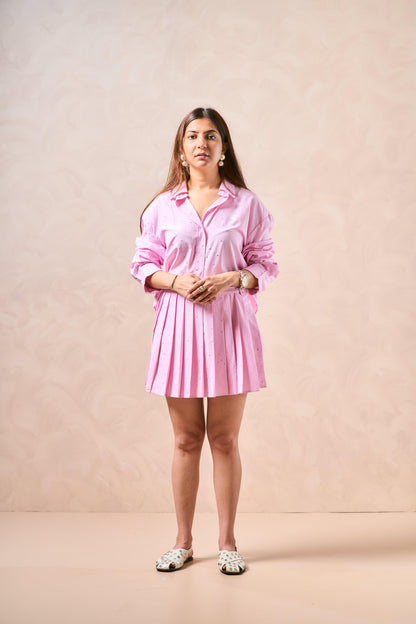 Woman wearing a pink dress against a beige background